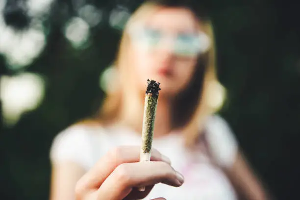 Woman holding marijuana joint