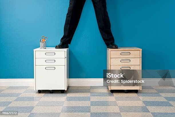 Businessman Standing On File Cabinets Stock Photo - Download Image Now - Baseboard, Blue, Business