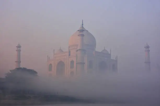 View of Taj Mahal in early morning fog, Agra, Uttar Pradesh, India. Taj Mahal was designated as a UNESCO World Heritage Site in 1983.