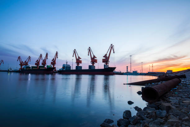 istock Gantry crane and cargo ship in the evening, Shipping and logistic concept 1155779477
