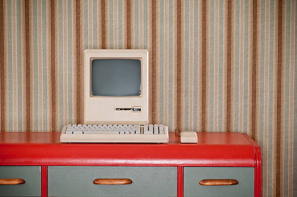 Old Classic Computer On Retro Desk Old classic computer sitting on an art deco retro desk. The wall is covered in a wallpaper with a striped wallpaper.* computer mouse photos stock pictures, royalty-free photos & images
