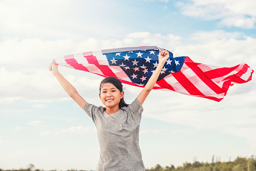 Happy asian little girl with American flag USA celebrate 4th of July