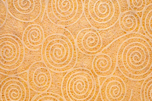 Japanese Washi tissue with white Uzumaki pattern spirals against marbled mulberry paper