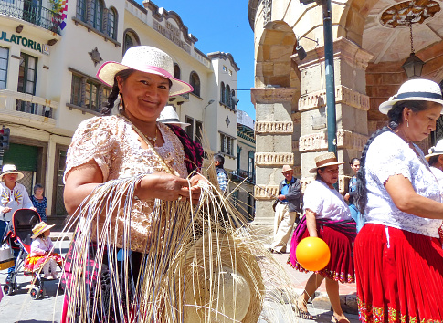 Mid-shot front view of two indigenous Peruvian women looking at camera while standing in Plaza Mayor, Cusco, Perú