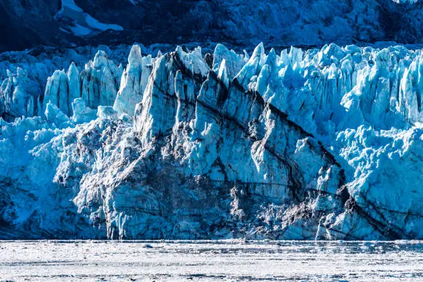 Rockface/rock face of Johns Hopkins Glacier & floating ice, Glacier Bay National Park and Preserve Alaska, a 12 mile long glacier in the tidewater inlet basin. Close up details captured October 2017.