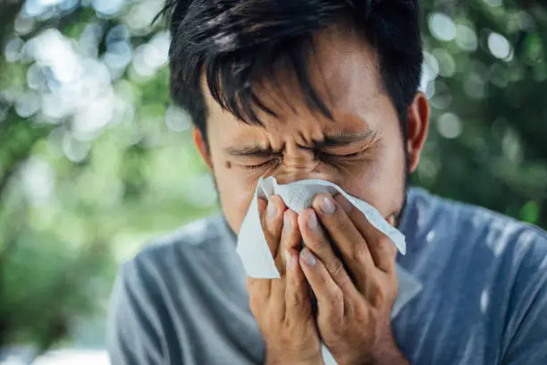 Young Man coughing and covering mouth with a tissue , take care of your Health concept , Health care concept