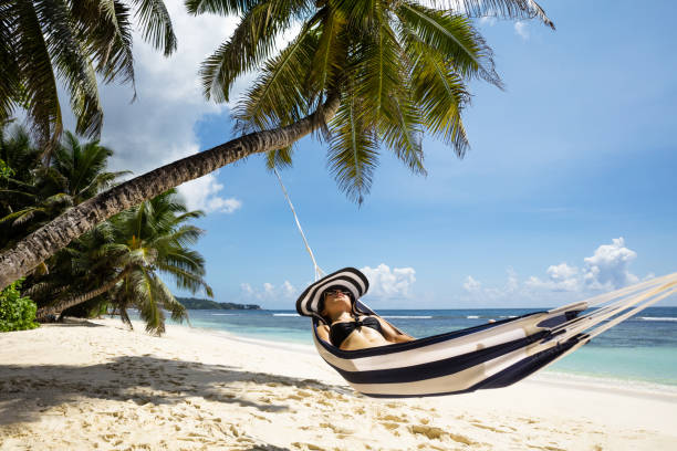 istock Young Woman Lying On Hammock Over Sandy Beach 1155812008