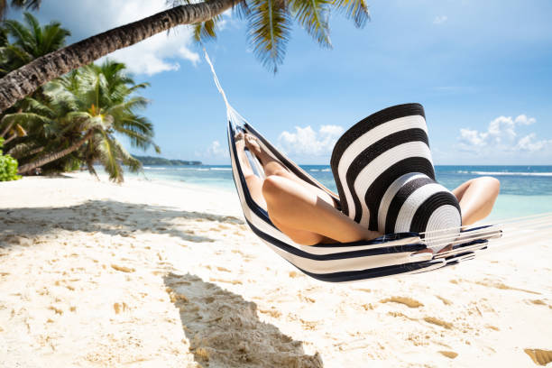 istock Woman Relaxing On Hammock Over The Idyllic Beach 1155812021