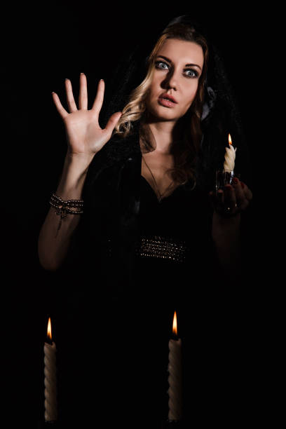 istock Mysterious young woman with a candle 1155812216