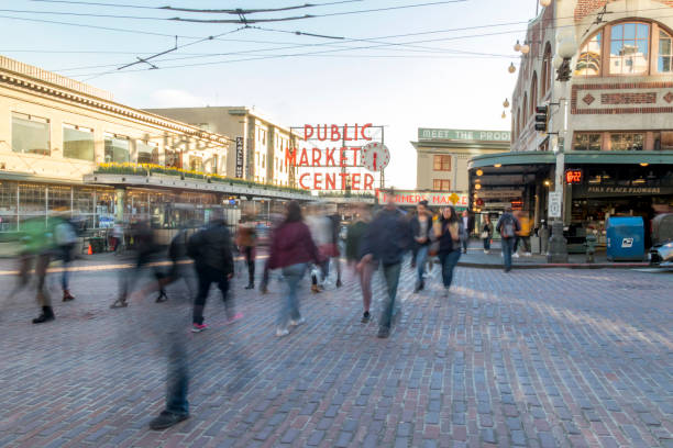 foto a lunga esposizione di persone che attraversano la strada di fronte al public market center sulla 1st avenue e pike place nel centro di seattle. - foreigner foto e immagini stock