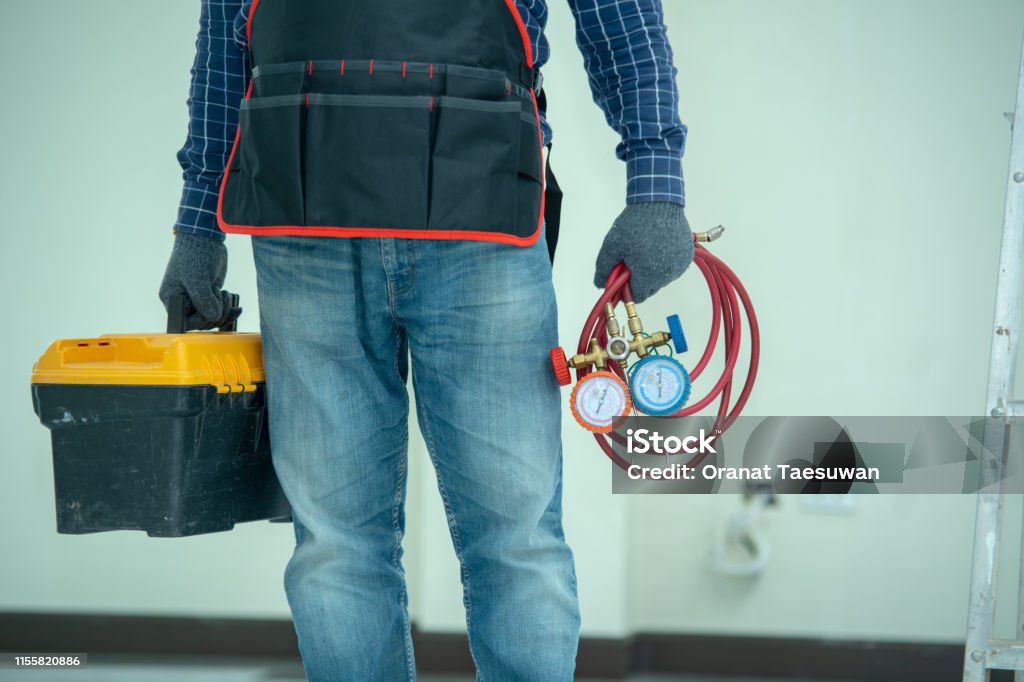 The technician is checking the air system. The technician is checking the air system,measuring equipment for filling air conditioners. Air Conditioner Stock Photo