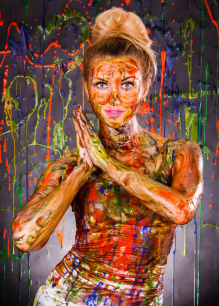 istock Beautiful woman covered with multicolored paints 1155821833