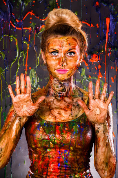 istock Beautiful woman covered with multicolored paints 1155821835
