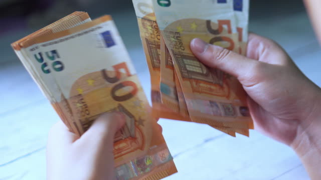 Woman Hands counting Euro banknotes money and calculator cost.