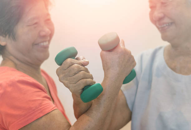 istock Strong and healthy senior old people holding  dumbbells for doing exercise or physical therapy in nursing home. 1155828048