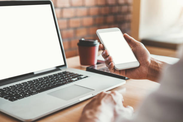 istock Businesss man using laptop and Mobile Phone with blank screen  in the office. 1155828198