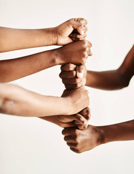 building up a tower of strength - women standing fist success imagens e fotografias de stock