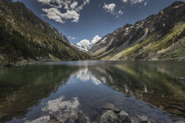 Europe, France, Pyrenees, 06-2019, idílico paisaje veraniego en las montañas francesas, el lago gaube es un lago en los pirineos franceses, en el departamento de los altos pirineos, cerca de la ciudad de cauterets. paisaje con altas montañas y picos cubiertos de nieve y cielo azul.