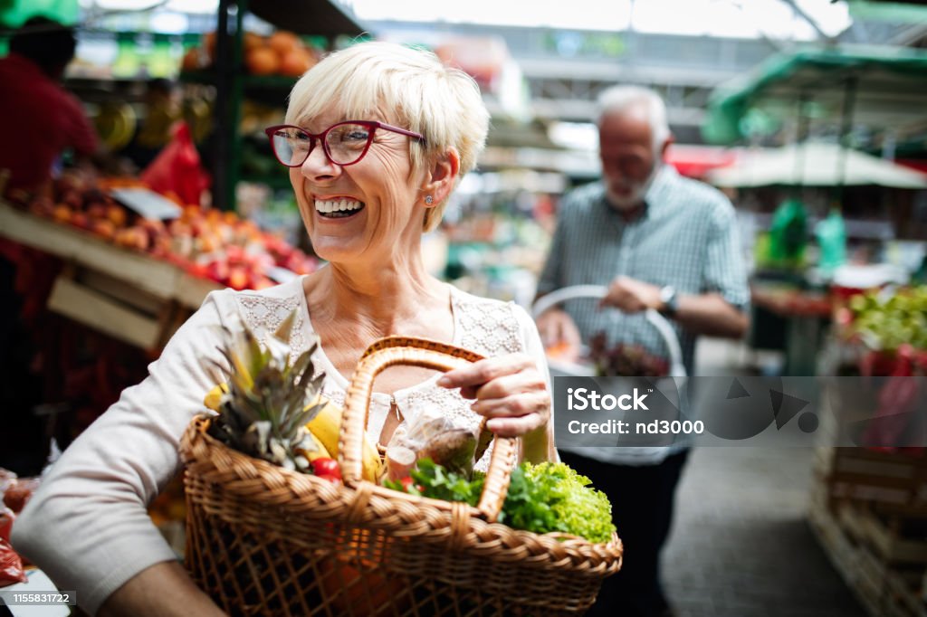 Seniorenpaar, das frisches Gemüse und Obst auf dem lokalen Markt kauft - Lizenzfrei Alter Erwachsener Stock-Foto