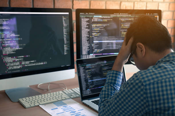 Software developers headache with code analysis in the office. stock photo
