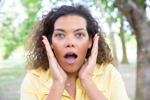 istock Shocked woman looking at camera in park 1155837107