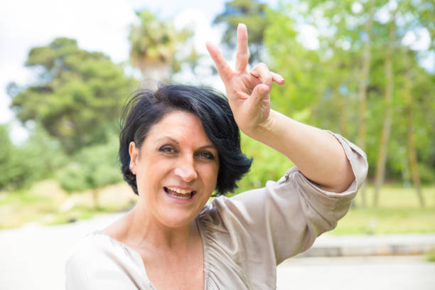 istock Cheerful middle aged woman having fun in park 1155838219