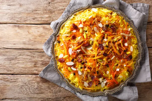Javaher Polow (jeweled rice) is a traditional Persian rice dish closeup on a plate on the table. horizontal top view from above