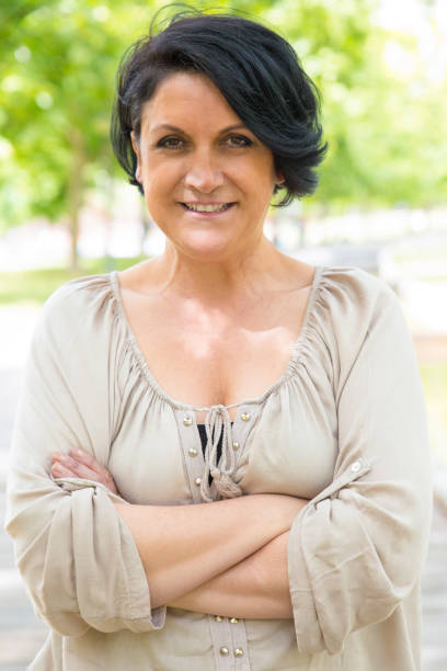 istock Happy confident woman posing in park 1155838248