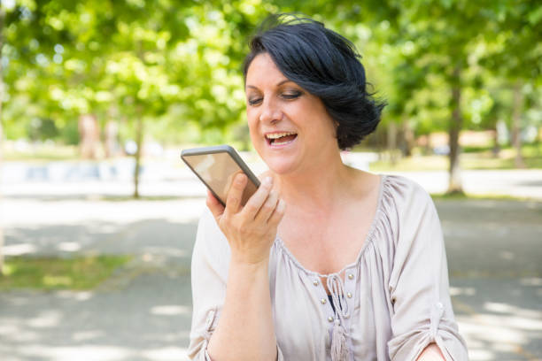 istock Happy positive woman recording voice message 1155838270