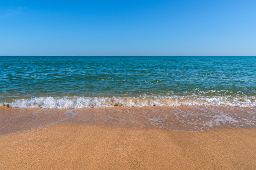 Empty summer beach with golden sand and azure water