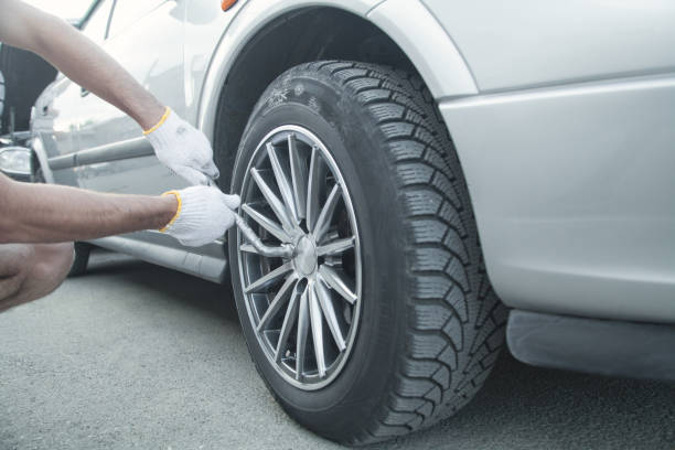 istock Changing car tire. Car service. Tire installation concept 1155840195