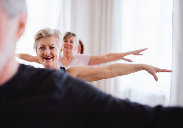 istock Group of senior people doing exercise in community center club. 1155840384