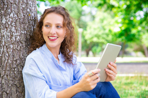 istock Excited pretty woman enjoying mobile app on tablet 1155840477