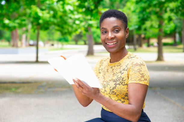 istock Positive pretty Black woman with interesting book 1155840522