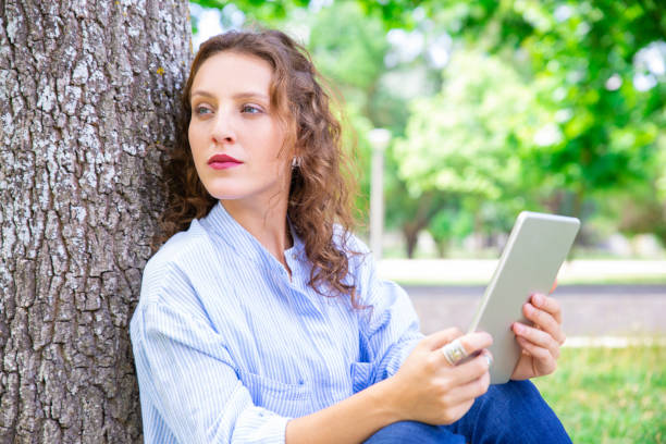 Pensive lady journalist thinking about article in park