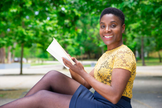 istock Smiling young Black woman reading book 1155840550