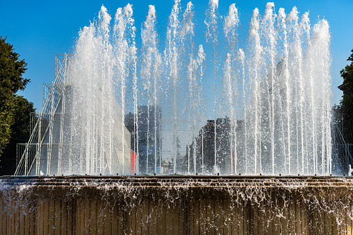 Fountain splashes on a clear blue sky. Piazza Castello, Milan, Lombardy, Italy