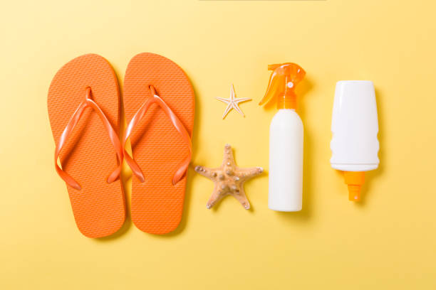 istock Sunscreen bottle or body spray on yellow background top view flat lay with copy space. Holiday vacation travel concept with beach sea accessories 1155841602