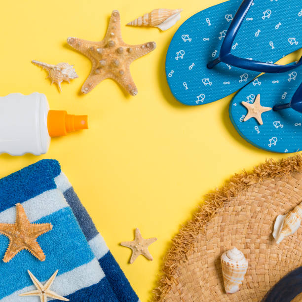 istock flip flops, straw hat, starfish, sunscreen bottle, body lotion spray on yellow background top view . flat lay summer beach sea accessories background, holiday concept 1155841607