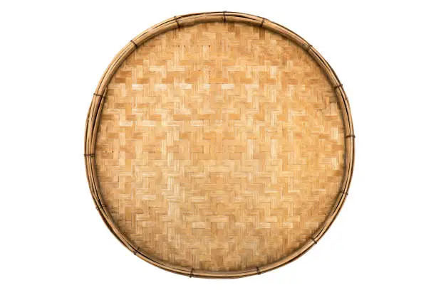 Photo of Old weave bamboo wood tray isolated on white background. Bamboo basket handmade isolated
