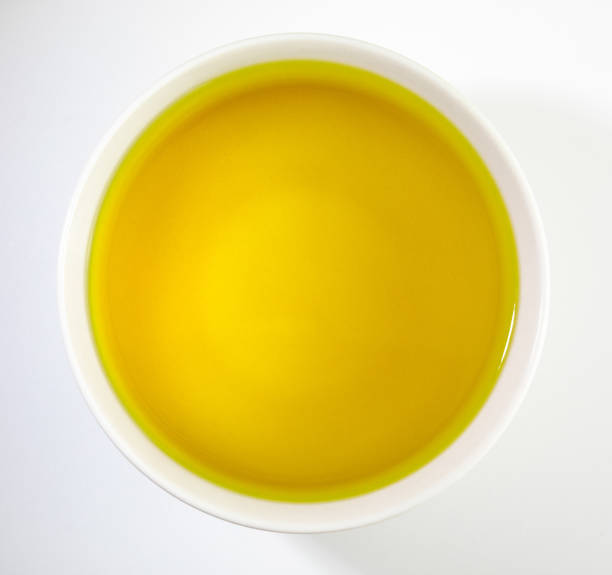 bowl of extra virgin olive oil. close-up, with overhead view on white background. - virgin olive oil imagens e fotografias de stock