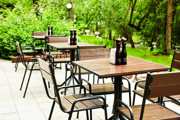 istock Empty woode tables and chairs in the outdoor cafe ready for visitors. 1155847358