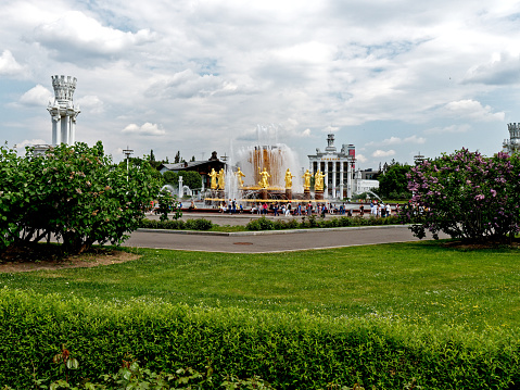Moscow, Russia - May 28, 2019: a lot of people are resting around Peoples' Friendship fountain in VDNKh