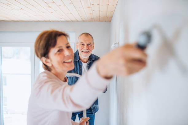 istock Senior couple painting walls in new home, relocation concept. 1155850708