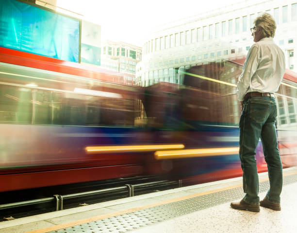 istock Commuter waiting at station with blurred motion of speeding train 1155851049