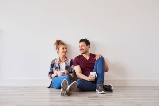 Smiling couple with coffee taking break from moving home