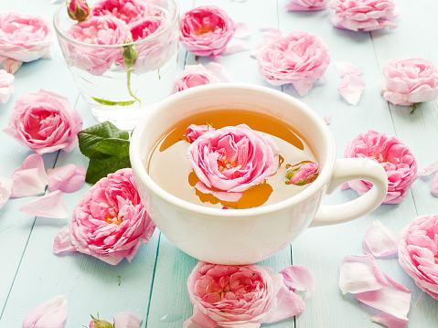 Cup of tea-rose tea and fresh flowers. Shallow dof.