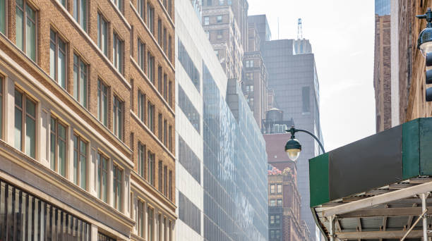 istock New York, Manhattan. High buildings view from below against blue sky background 1155854112