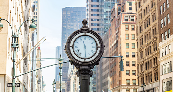 New York, Manhattan 5th ave. Big street cast iron clock on skyscrapers background