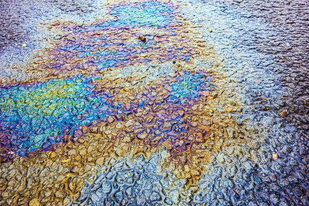 istock Oil Petrol Pollution Leak Rainbow Stain on Pavement 1155854275